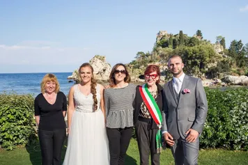 Sposi e interprete giurata dopo un matrimonio a Taormina, con Isola Bella alle spalle