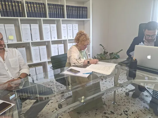 Lucyna Dulęba durante una firma dal notaio in Sicilia, con i clienti al tavolo