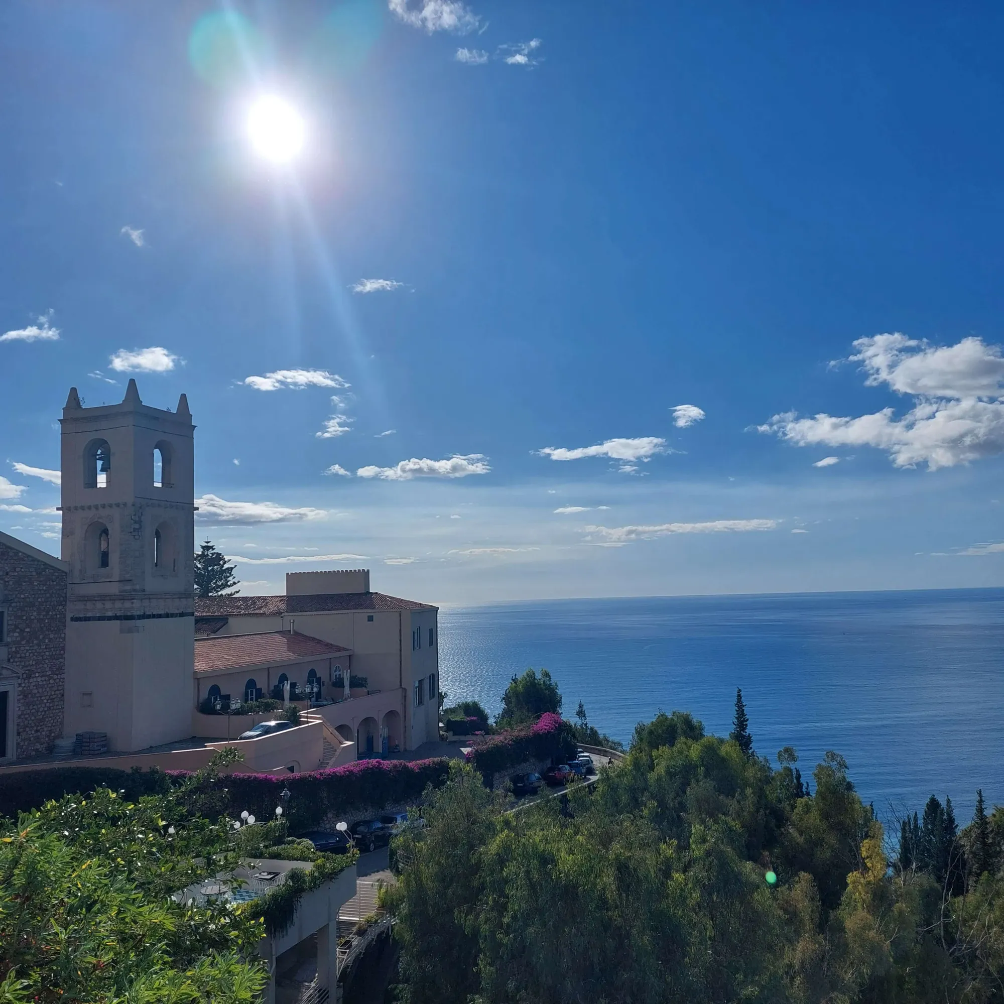 Taormina, in Sicilia: il campanile del Duomo, il mare Ionio e le bouganville